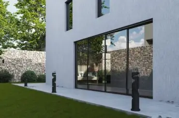 A contemporary white house with large windows and a spacious grass lawn.