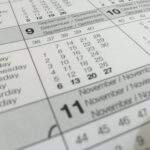 Detailed close-up of a calendar displaying months in several languages.
