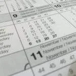Detailed close-up of a calendar displaying months in several languages.